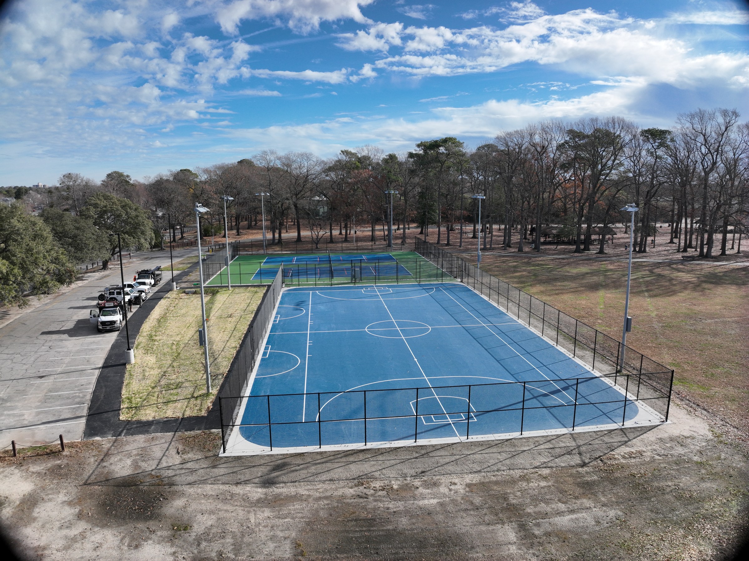 The finished playing surface, line markings, and enclosure viewed from the end of the court.