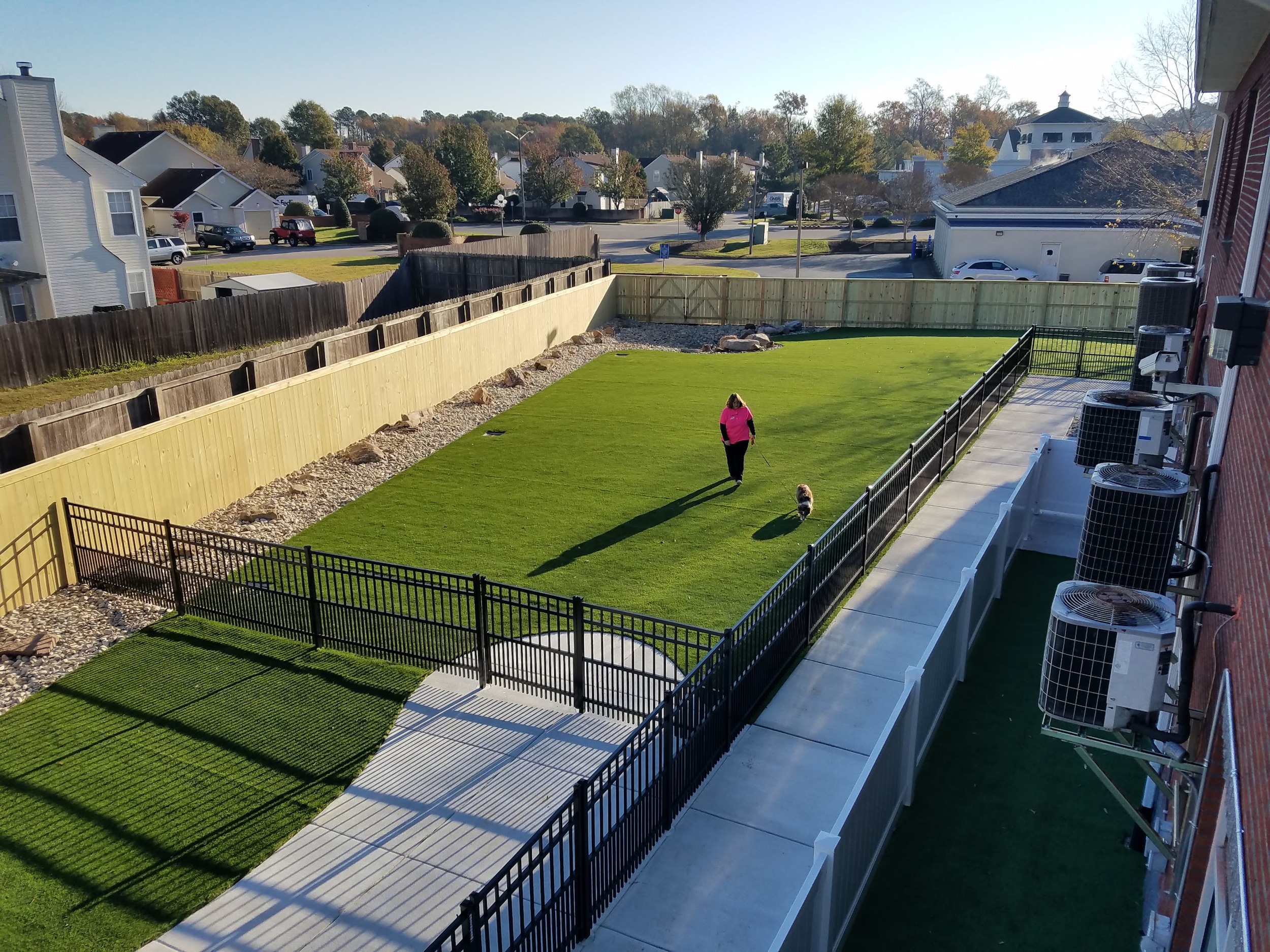 Finished turf, fencing, and concrete paths define the dog exercise areas.