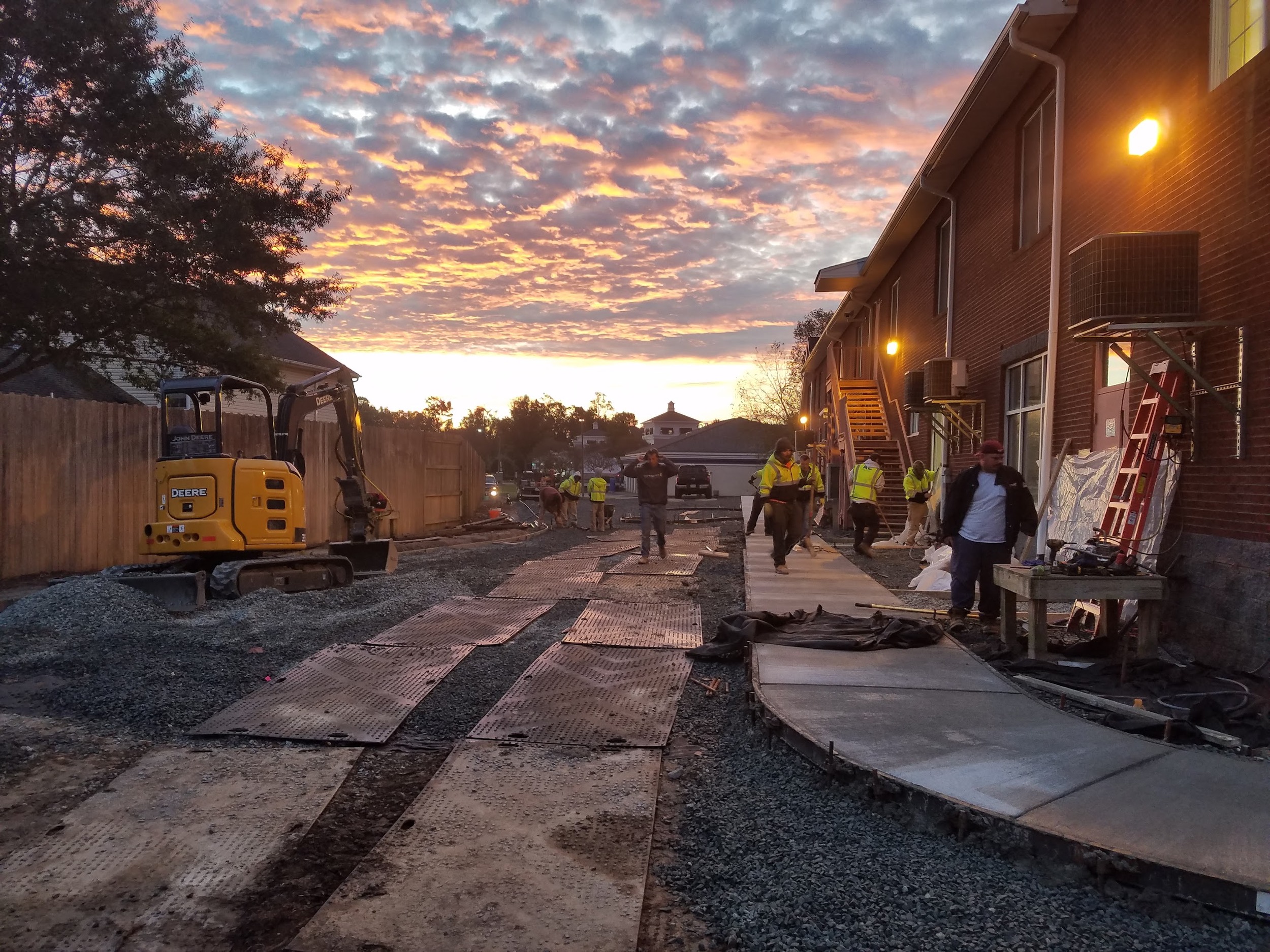 Crews and equipment prepare for the day within the constrained work area.