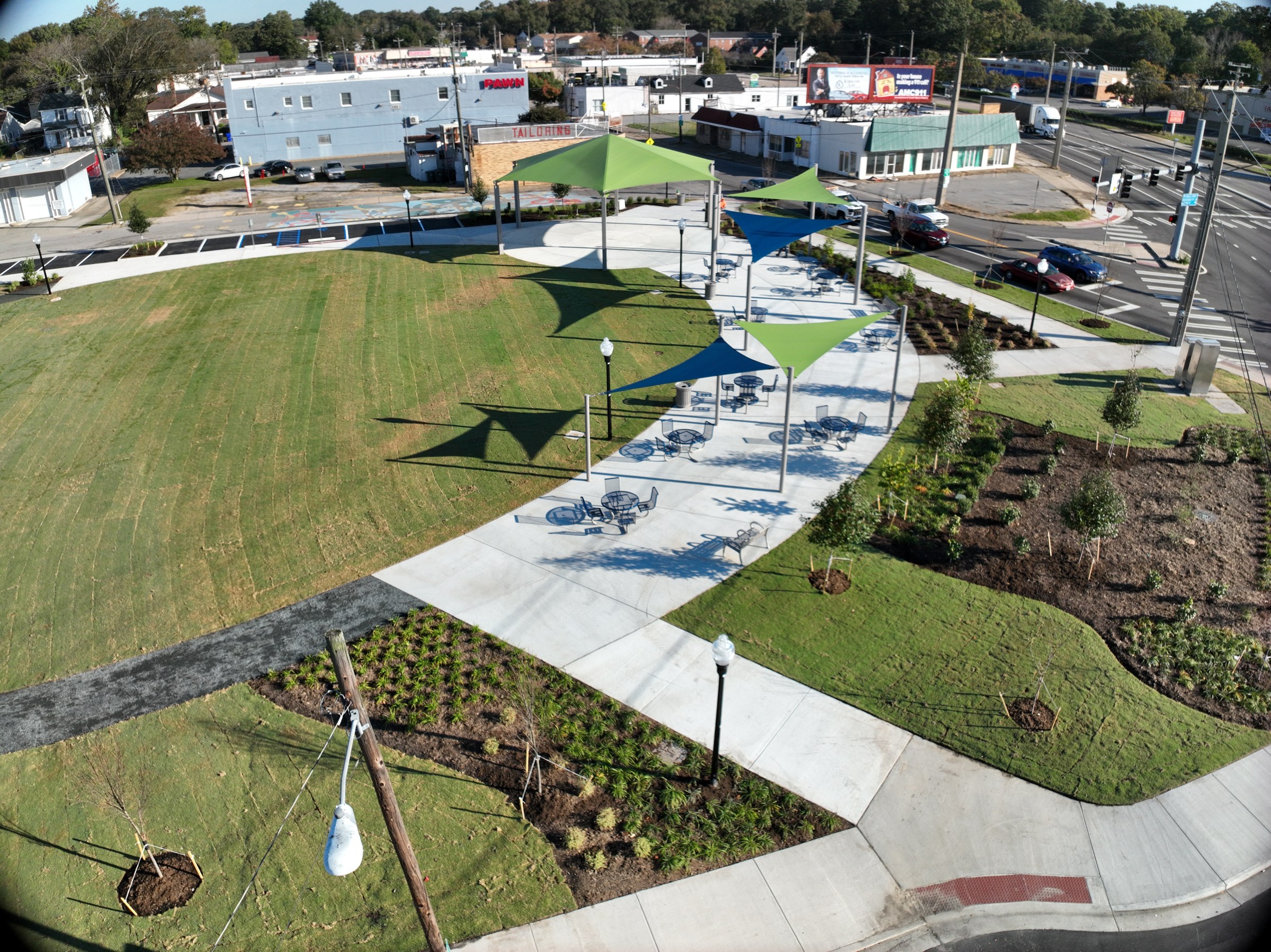 Curved park paths, shade shelters, and lawn viewed from above
