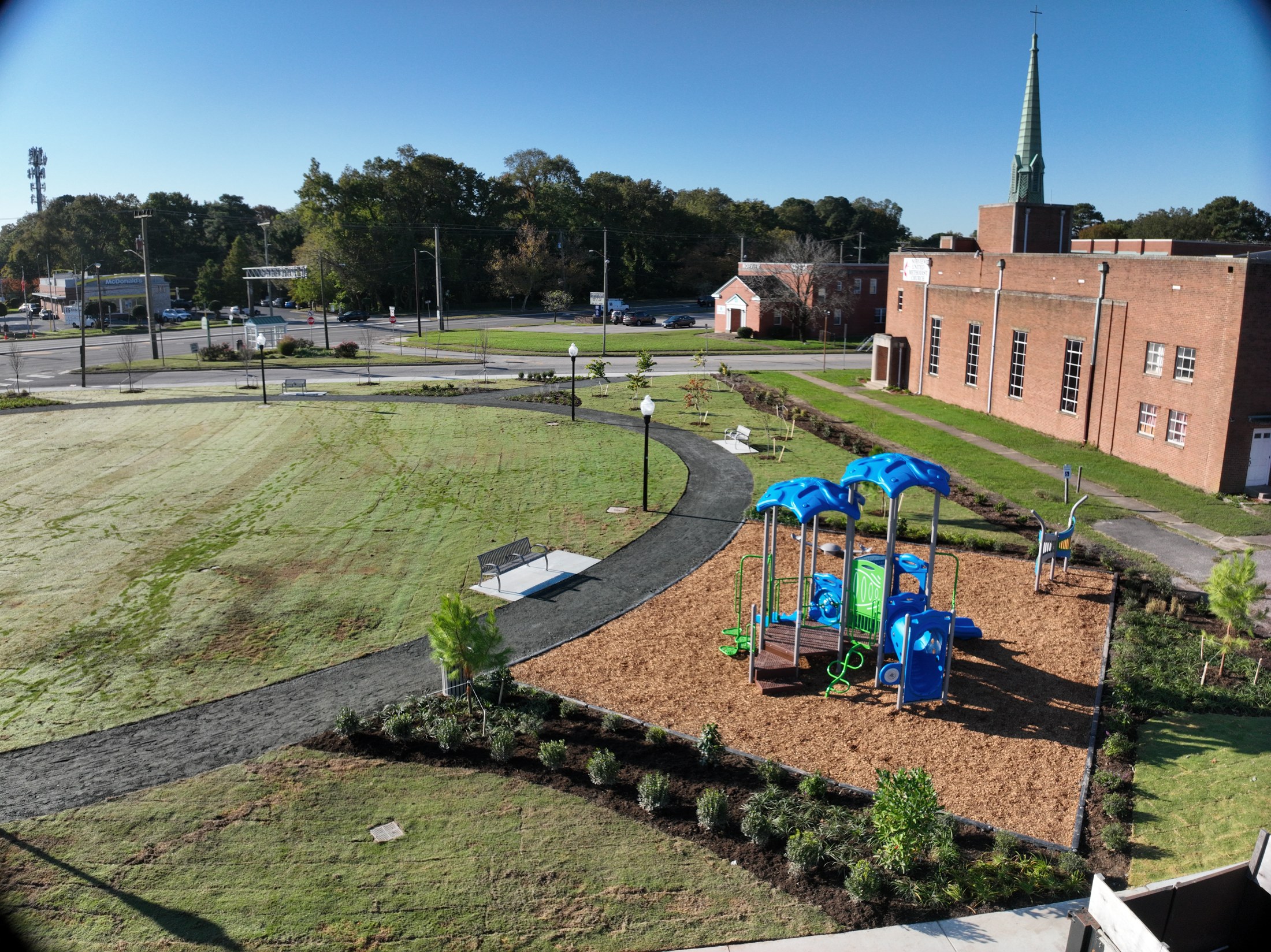 Play equipment, connecting paths, benches, and planting within the completed park layout.